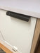 100mm matte black drawer latch attached to white cabinet