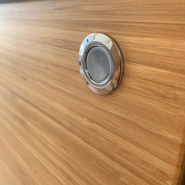 Stainless steel push lock installed in brown cabinet